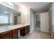 Bathroom with a double sink vanity, tile floors, and doors leading to closet and other rooms at 2482 Brittany Park Ln, Ellenwood, GA 30294