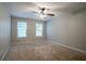 Neutral bedroom featuring a ceiling fan and carpeted floors, with natural light from two windows at 2482 Brittany Park Ln, Ellenwood, GA 30294