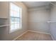 Walk-in closet featuring a window, wall mounted shelving, and carpeted floor at 2482 Brittany Park Ln, Ellenwood, GA 30294
