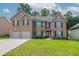 Charming two-story brick home with a well-manicured lawn and attached two-car garage in a suburban neighborhood at 2482 Brittany Park Ln, Ellenwood, GA 30294