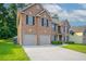 Charming two-story brick home with a well-manicured lawn and attached two-car garage in a suburban neighborhood at 2482 Brittany Park Ln, Ellenwood, GA 30294