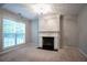 Bright living room featuring a fireplace with white mantle and a large window for natural light at 2482 Brittany Park Ln, Ellenwood, GA 30294