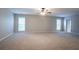 Large living room with neutral carpet, lots of natural light from big windows, and simple wall decor at 2482 Brittany Park Ln, Ellenwood, GA 30294