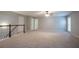 Upstairs living area featuring neutral carpeting and a wood railing at 2482 Brittany Park Ln, Ellenwood, GA 30294