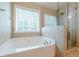 Spacious bathroom with a soaking tub and a glass-enclosed shower for a spa-like experience at 2870 Jay Oak Dr, Dacula, GA 30019