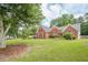 Lovely brick home with green lawn, mature trees, and manicured landscaping at 2870 Jay Oak Dr, Dacula, GA 30019