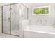 The luxurious bathroom features a marble shower and a soaking tub at 415 Paynes Lake Rd, Carrollton, GA 30116