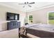 This large bedroom has a ceiling fan and a dresser with a large mirror at 415 Paynes Lake Rd, Carrollton, GA 30116