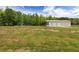 Expansive lot featuring a large outbuilding with multiple garage doors, providing ample space and potential at 415 Paynes Lake Rd, Carrollton, GA 30116