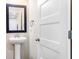 This powder room features a pedestal sink and black framed mirror at 415 Paynes Lake Rd, Carrollton, GA 30116