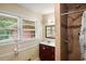 Bathroom featuring a tiled walk-in shower, vanity with storage, and a bright window at 5343 Crystal Ln, Atlanta, GA 30349