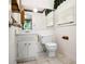 Bright bathroom featuring a white vanity, toilet, and tiled floors, plus a window for natural light at 5343 Crystal Ln, Atlanta, GA 30349