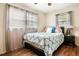 Cozy bedroom featuring hardwood floors, large windows with curtains, and a comfortable bed at 5343 Crystal Ln, Atlanta, GA 30349
