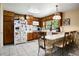 Functional kitchen featuring wood cabinets, white appliances, tile floors, and seating at the breakfast bar at 5343 Crystal Ln, Atlanta, GA 30349