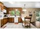 Eat-in kitchen featuring wood cabinets, white appliances, tile floors, and a view to the backyard at 5343 Crystal Ln, Atlanta, GA 30349