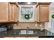 Well-equipped kitchen featuring granite countertops, stainless steel sink, and tile backsplash, perfect for cooking at 1058 Magnolia Dr, Villa Rica, GA 30180