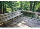 A wooded deck with a built-in bench provides a space to enjoy nature at 157 Sequoyah Cir, Canton, GA 30115