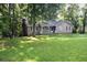 Cozy single-story home featuring a welcoming front porch and surrounded by a lush green lawn and mature trees at 157 Sequoyah Cir, Canton, GA 30115