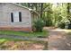 View of a home's exterior showcasing the siding, window with black shutters, and partial driveway at 157 Sequoyah Cir, Canton, GA 30115