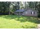 Charming single-story home with a gray exterior and a well-manicured front lawn surrounded by lush trees at 157 Sequoyah Cir, Canton, GA 30115