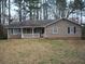 Cozy home with a welcoming front porch and mature trees in a private, wooded setting at 157 Sequoyah Cir, Canton, GA 30115