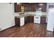 A kitchen featuring brown cabinets, laminate countertops, white appliances, and wood-look flooring at 157 Sequoyah Cir, Canton, GA 30115