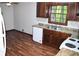 Traditional kitchen with brown cabinets, a white dishwasher, and a double stainless steel sink with wood look floors at 157 Sequoyah Cir, Canton, GA 30115