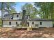 View of home's back exterior showcasing a new deck, neutral siding, and brick chimney at 4617 Cedar Park Dr, Stone Mountain, GA 30083
