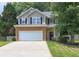 Charming two-story home featuring a two-car garage, stone accents, black shutters, and a well-manicured lawn at 112 Lexington Parke Dr, Woodstock, GA 30189