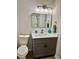 Stylish bathroom features a gray vanity with white counter, toilet and tub/shower highlighted by modern light fixture at 1743 Moss Dr, Snellville, GA 30078