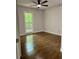 Bright bedroom boasts hardwood floors, a ceiling fan, and a large window offering natural light at 1743 Moss Dr, Snellville, GA 30078