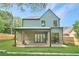 Expansive backyard featuring a covered patio, brick accents, and a lush green lawn at 504 Barrington Drive, Roswell, GA 30075