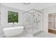 Bright bathroom with a soaking tub and glass enclosed shower with marble tile at 504 Barrington Drive, Roswell, GA 30075