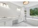 Bright bathroom with dual vanities, bathtub, marble floors and a large window with a view at 504 Barrington Drive, Roswell, GA 30075