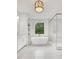 Serene bathroom featuring a soaking tub, glass shower, marble floors, and modern fixtures with backyard view at 504 Barrington Drive, Roswell, GA 30075