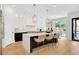Open kitchen with a large island, designer lighting, and access to the outdoor dining area at 504 Barrington Drive, Roswell, GA 30075