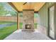 Outdoor patio with a brick fireplace, wood ceiling, and serene backyard at 504 Barrington Drive, Roswell, GA 30075