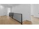 Bright hallway features hardwood floors and iron railing at 6132 Hutchins Dr, Buford, GA 30518