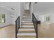 A staircase with black iron railings and hardwood stairs leads to an open-concept living space at 6132 Hutchins Dr, Buford, GA 30518