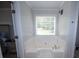 The bathroom featuring a soaking tub with a large window bringing in natural light at 10 Stagg Trce, Social Circle, GA 30025