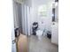 Tiled bathroom featuring a toilet, shower with curtain, vanity with sink, and storage at 10 Stagg Trce, Social Circle, GA 30025