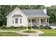 Charming one-story home featuring a welcoming porch, manicured lawn, and blooming hydrangea bushes at 10 Stagg Trce, Social Circle, GA 30025