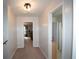 Carpeted hallway leading to an office and bathroom with neutral paint color and modern light fixture at 10 Stagg Trce, Social Circle, GA 30025