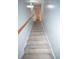 Carpeted stairwell with wooden handrail leads to upper level, providing a seamless transition between floors at 10 Stagg Trce, Social Circle, GA 30025
