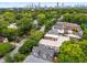 Partial aerial view features the roof, tree lined neighborhood and distant skyline in the background at 1038 Saint Charles Ave, Atlanta, GA 30306