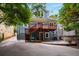 Back of the house features a wood deck with stairs and a stone patio with lush trees at 1038 Saint Charles Ave, Atlanta, GA 30306