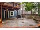 A stone backyard patio features outdoor seating and a view of a deck and the back of the home at 1038 Saint Charles Ave, Atlanta, GA 30306