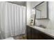 Bathroom features granite vanity, framed mirror, and shower with curtain at 1038 Saint Charles Ave, Atlanta, GA 30306