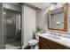 Bathroom with tiled shower, wood frame mirror and single sink vanity at 1038 Saint Charles Ave, Atlanta, GA 30306