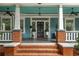 Inviting front porch with brick accents, white columns, and a stylish black front door at 1038 Saint Charles Ave, Atlanta, GA 30306